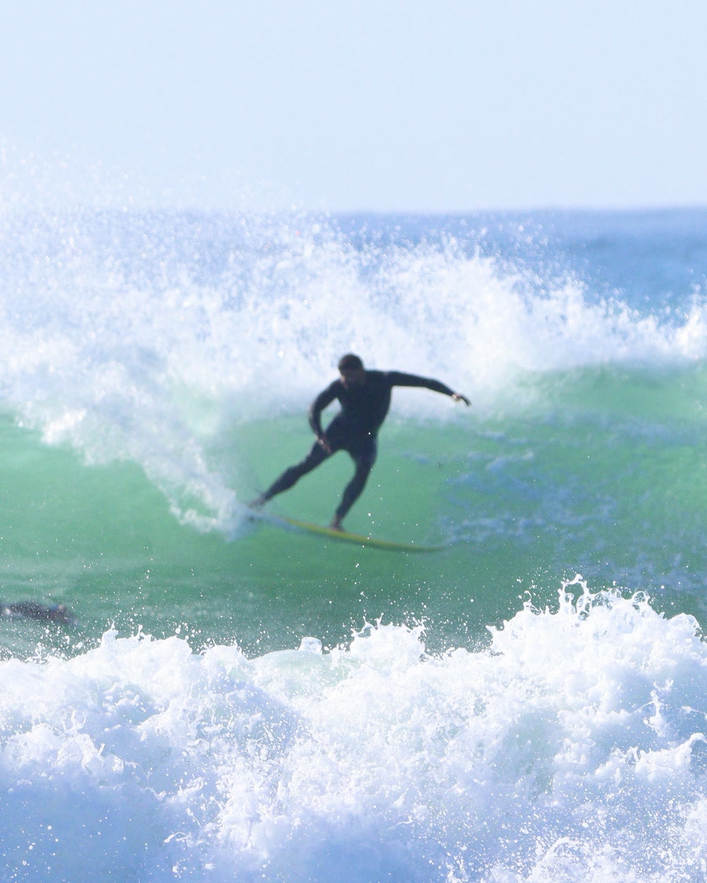 Surfer trimming down the line on an open wave face at Jeffreys Bay
