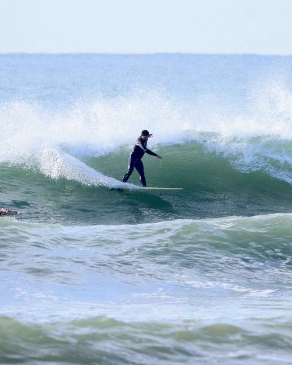 Longboarder gliding across an open wave face at Jeffreys Bay