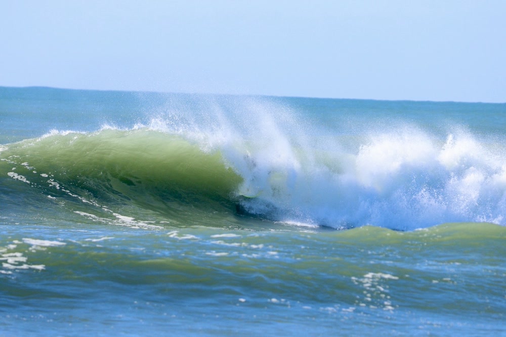 Barrel sequence, frame 4: the wave pitching over with the surfer behind the curtain